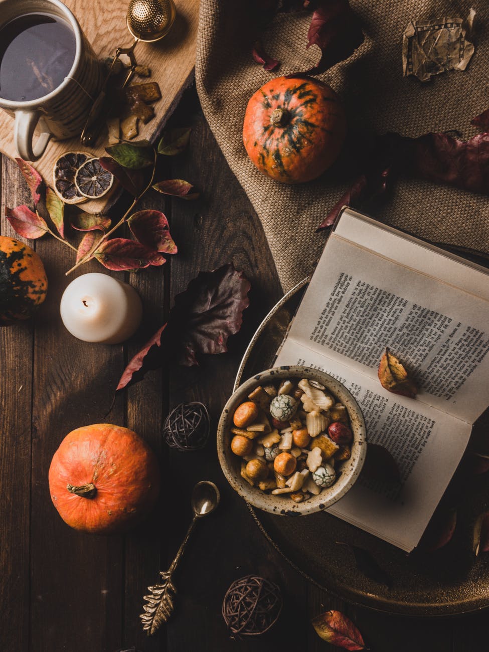 top view of a book and a cup of tea surrounded with an assortment of thing on top of a wooden table cheap halloween decorations pumpkin boo decor fall